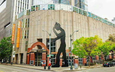 Seattle Art Museum entrance with Hammering Man sculpture, part of the Seattle Harbor of Secrets Golden Mermaid Hunt.