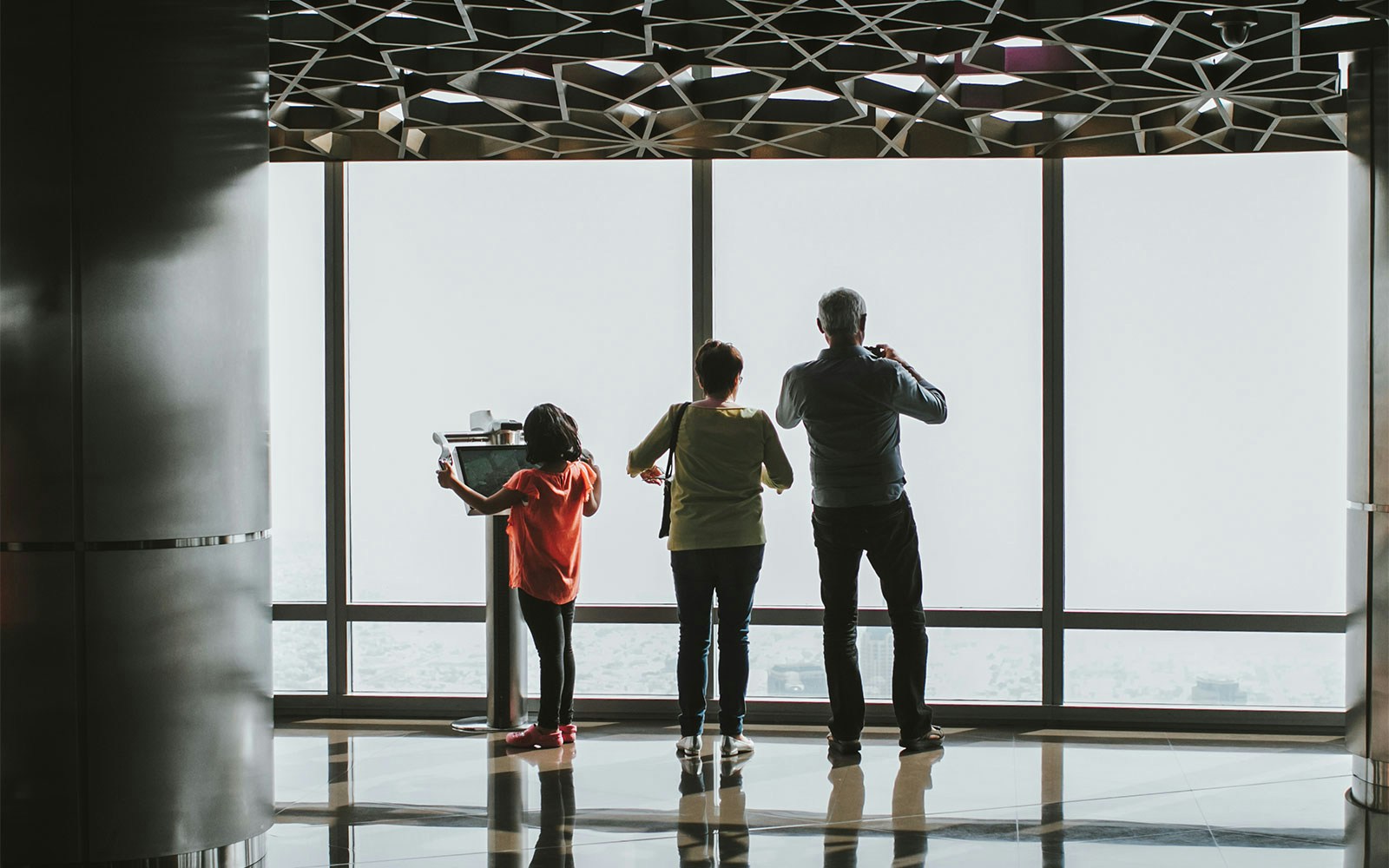 Tourists enjoying the panoramic view of Dubai city from At The Top, Levels 124 & 125 of Burj Khalifa with Fast Track Tickets