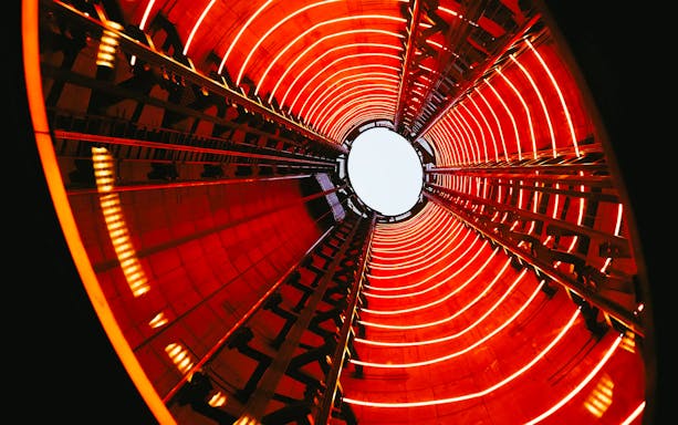 View from inside Lift 109 at Battersea Power Station with red neon lights.