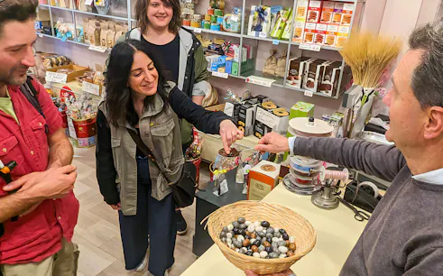 Tourists sampling local sweets in a Verona shop during a 1.5-hour guided food tour.
