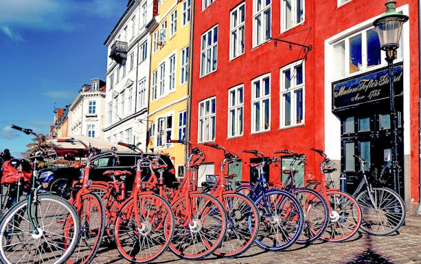 Bicycles lined up in front of colorful buildings in Copenhagen.