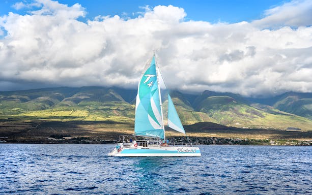Sailboat on Luxury West Snorkel Sail Tour in Maui, Hawaii with lush mountains in the background.