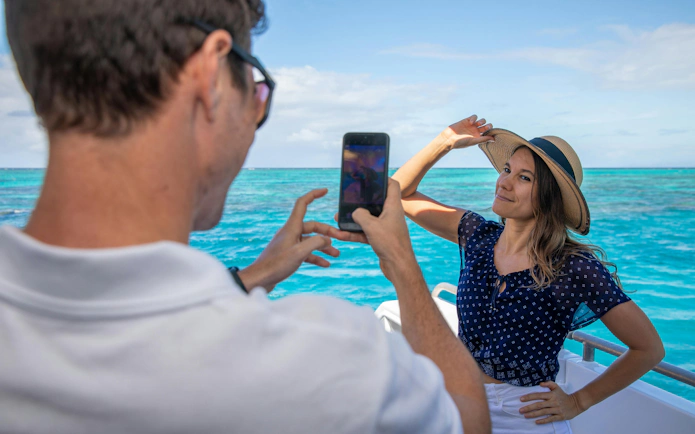 Person posing for a photo on a boat during a Cairns snorkeling tour.