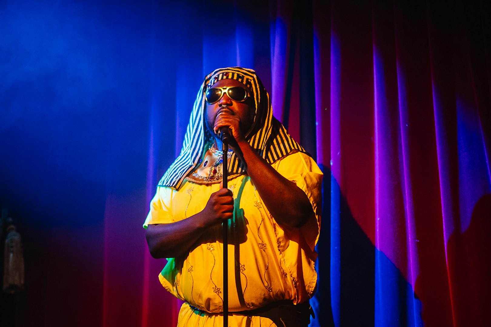 Performer in costume on stage at Miss Behaves: Maverick's Variety Show.