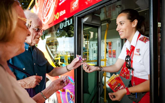 Guide interacting with tourists at Santa Cruz hop-on hop-off bus.