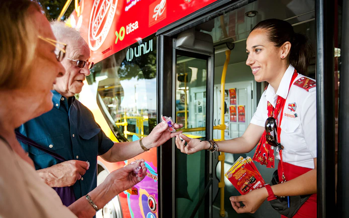 Guide interacting with tourists at Santa Cruz hop-on hop-off bus.