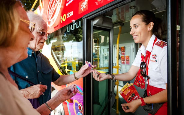 Guide interacting with tourists at Santa Cruz hop-on hop-off bus.