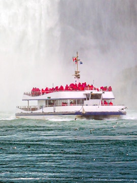 Hornblower cruise boat near Niagara Falls with passengers in red ponchos.