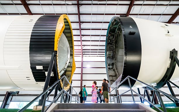 Visitors beneath Saturn V rocket at Houston Space Center, Texas.