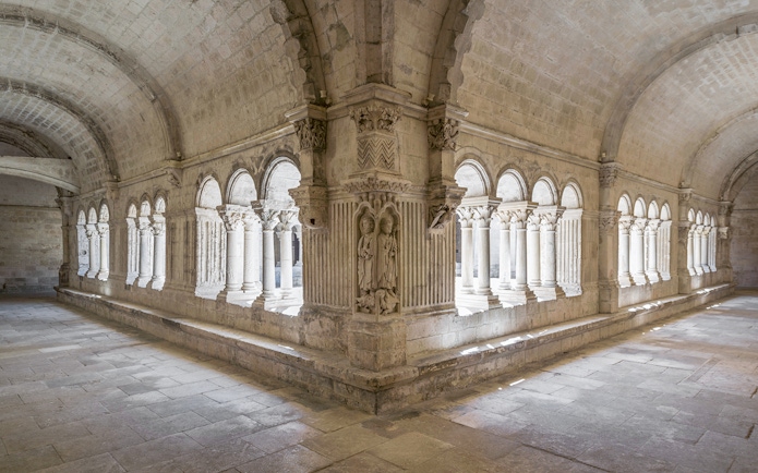 Cloister arches and stone carvings at Montmajour Abbey, France.