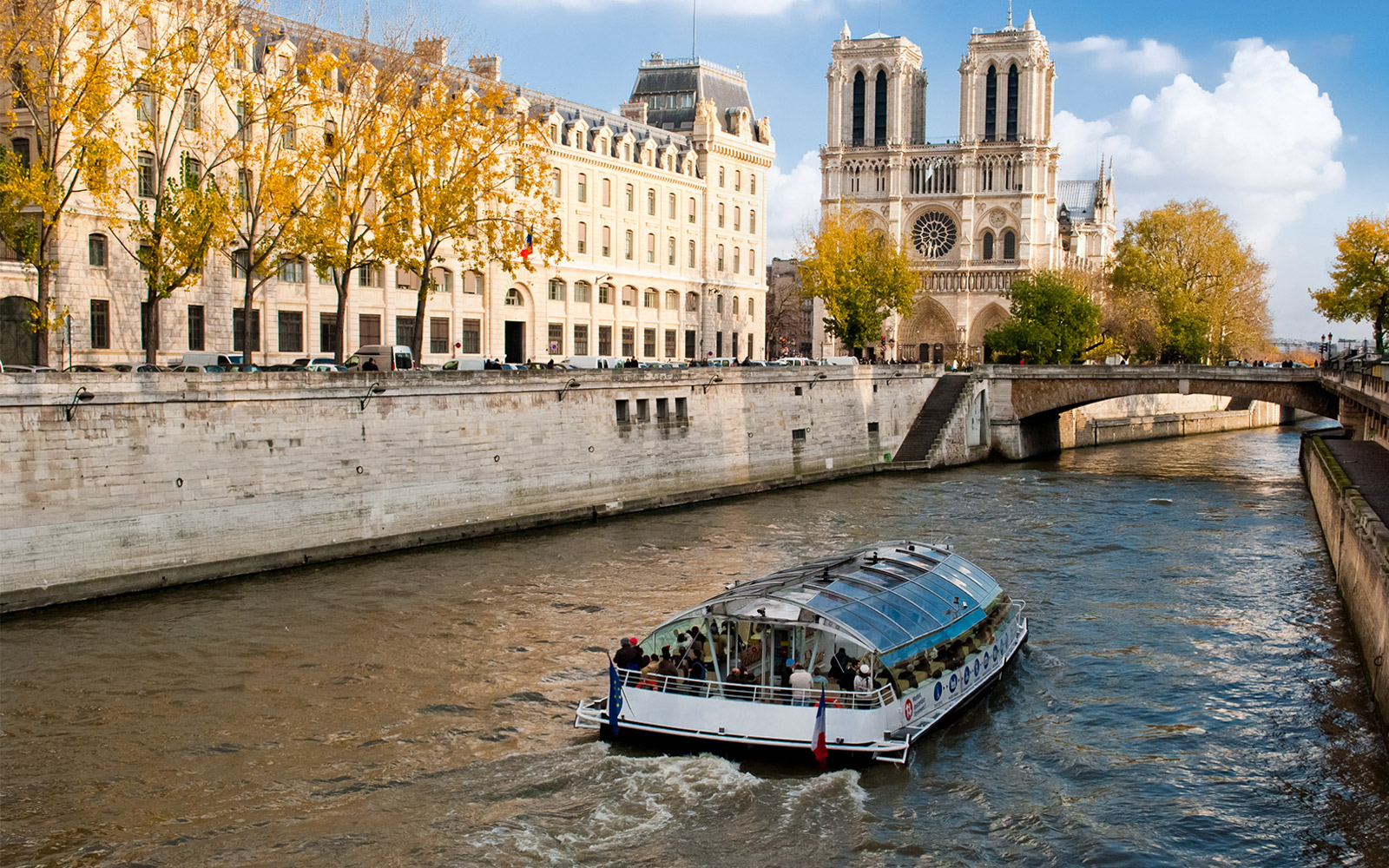 Bateaux Mouches riding over Seine River with people onboard.