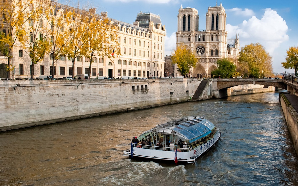 Seine River cruise boat near Notre-Dame Cathedral in Paris.