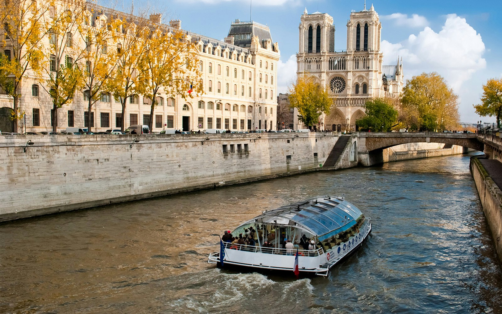 A bunch of poeple on a boat non chalantly touring around Paris.