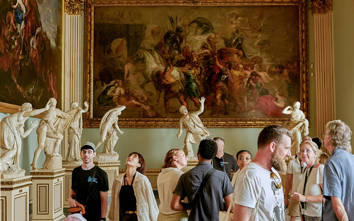 Visitors admiring 'Triumph of Henry IV' by Rubens at Uffizi Gallery, Florence.