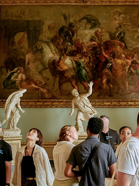Visitors admiring 'Triumph of Henry IV' by Rubens at Uffizi Gallery, Florence.