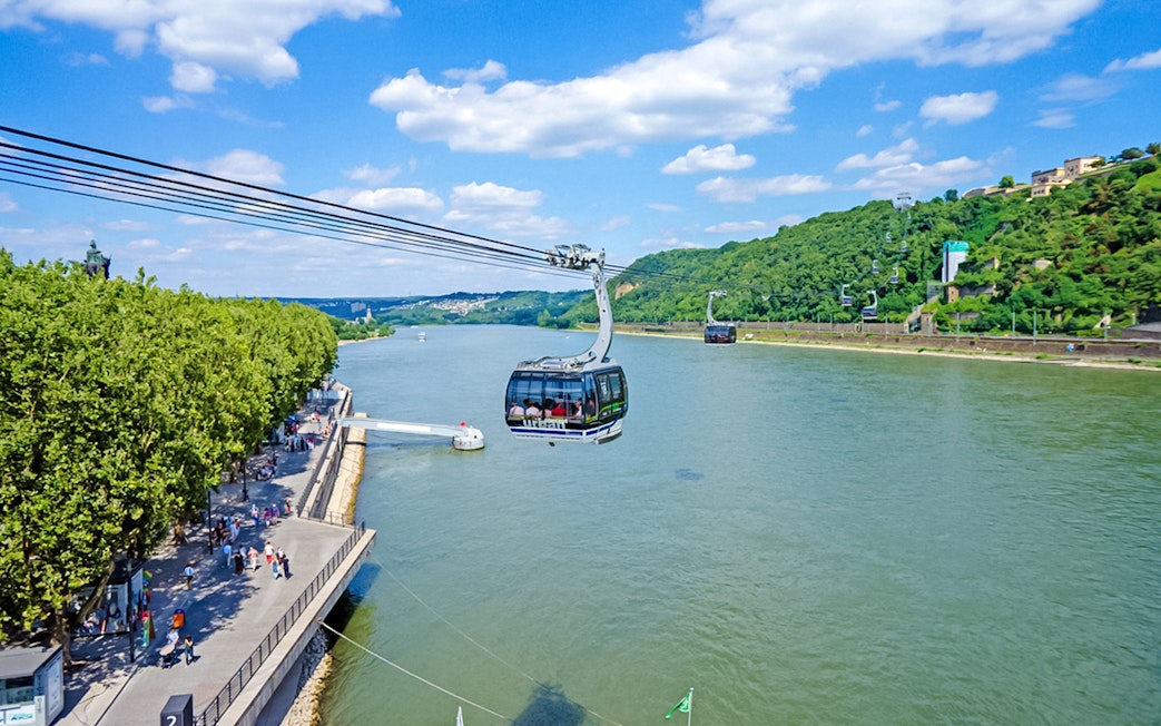 Koblenz Cable Car crossing the Rhine River with views of lush green hills.