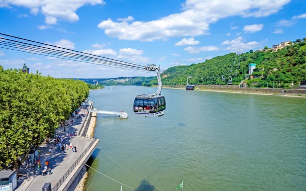 Koblenz Cable Car crossing the Rhine River with views of lush green hills.