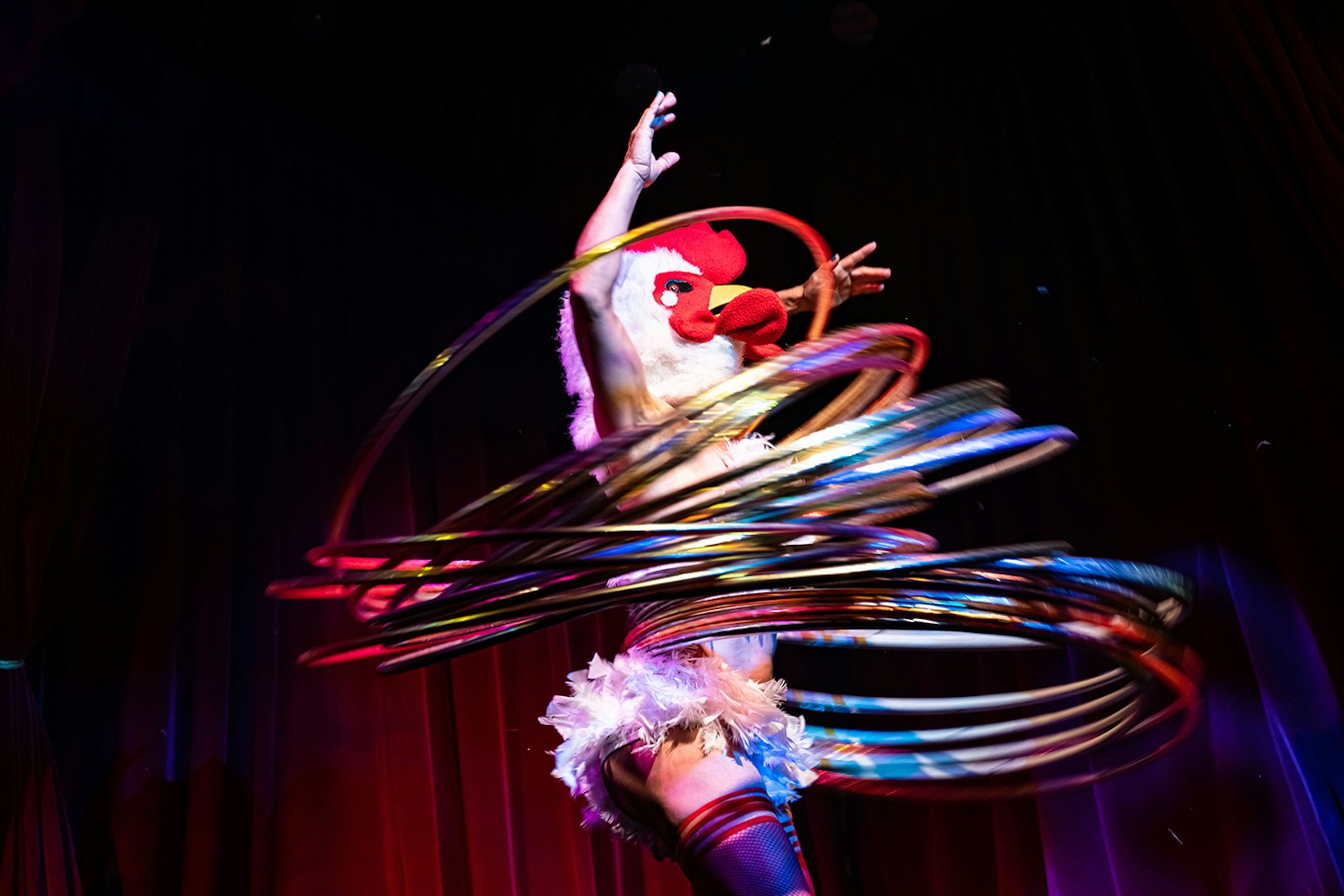 Performer in a chicken mask hula hooping at Miss Behaves: Maverick's Variety Show.