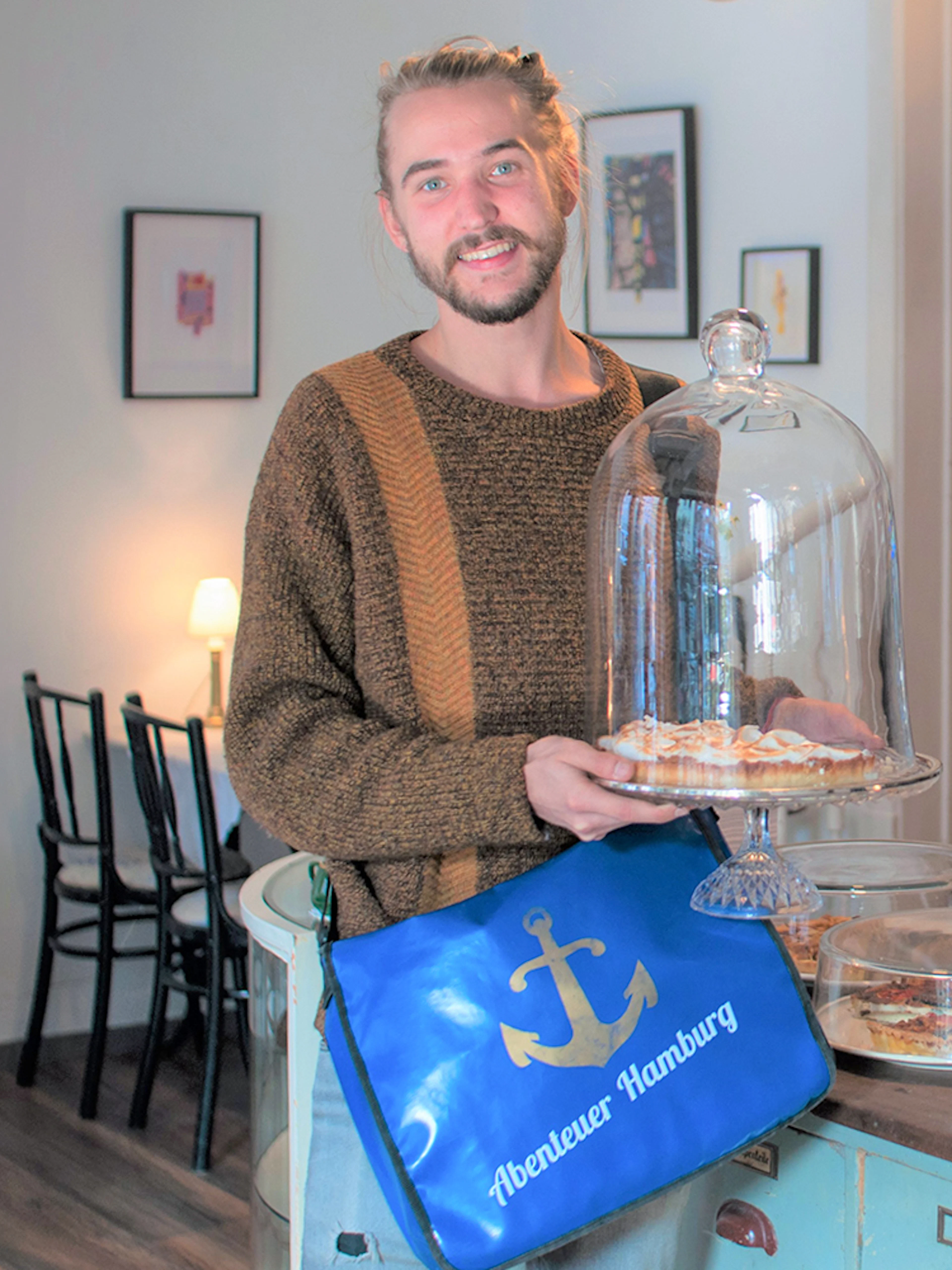 Man holding a dessert tray in a St. Pauli café during a guided culinary food tour.