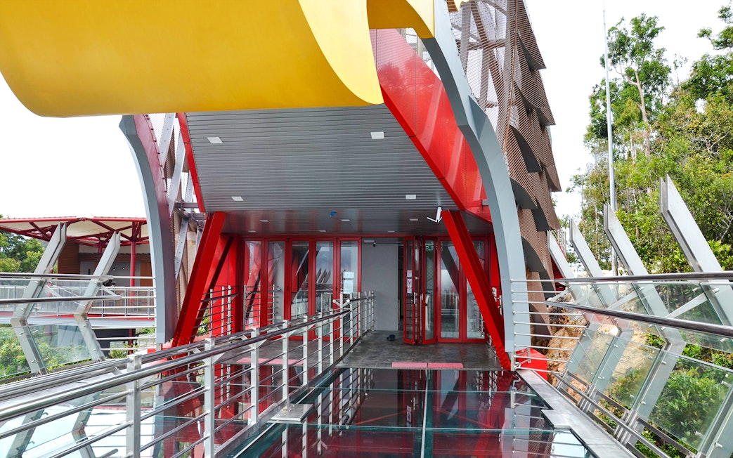Langkawi Skywalk entrance with glass floor and red steel beams.