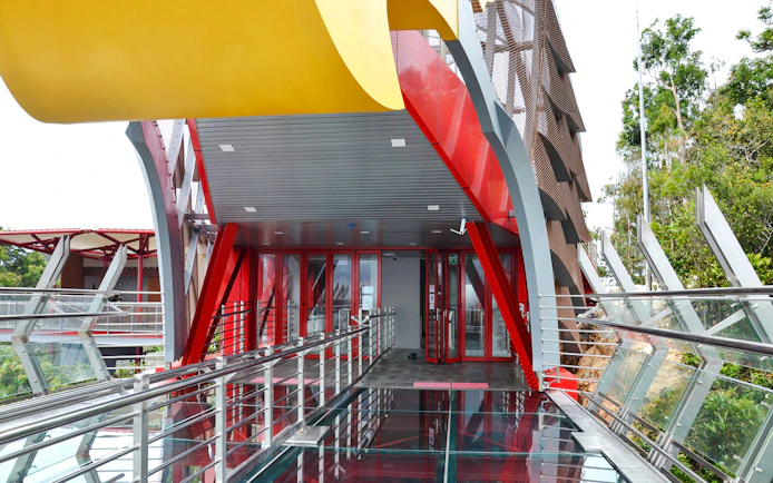Langkawi Skywalk entrance with glass floor and red steel beams.