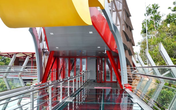 Langkawi Skywalk entrance with glass floor and red steel beams.