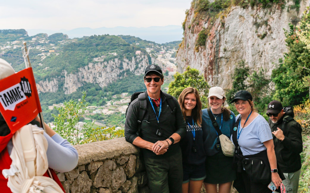 Group enjoying a tour of the Amalfi Coast at a scenic overlook near Capri, Italy.
