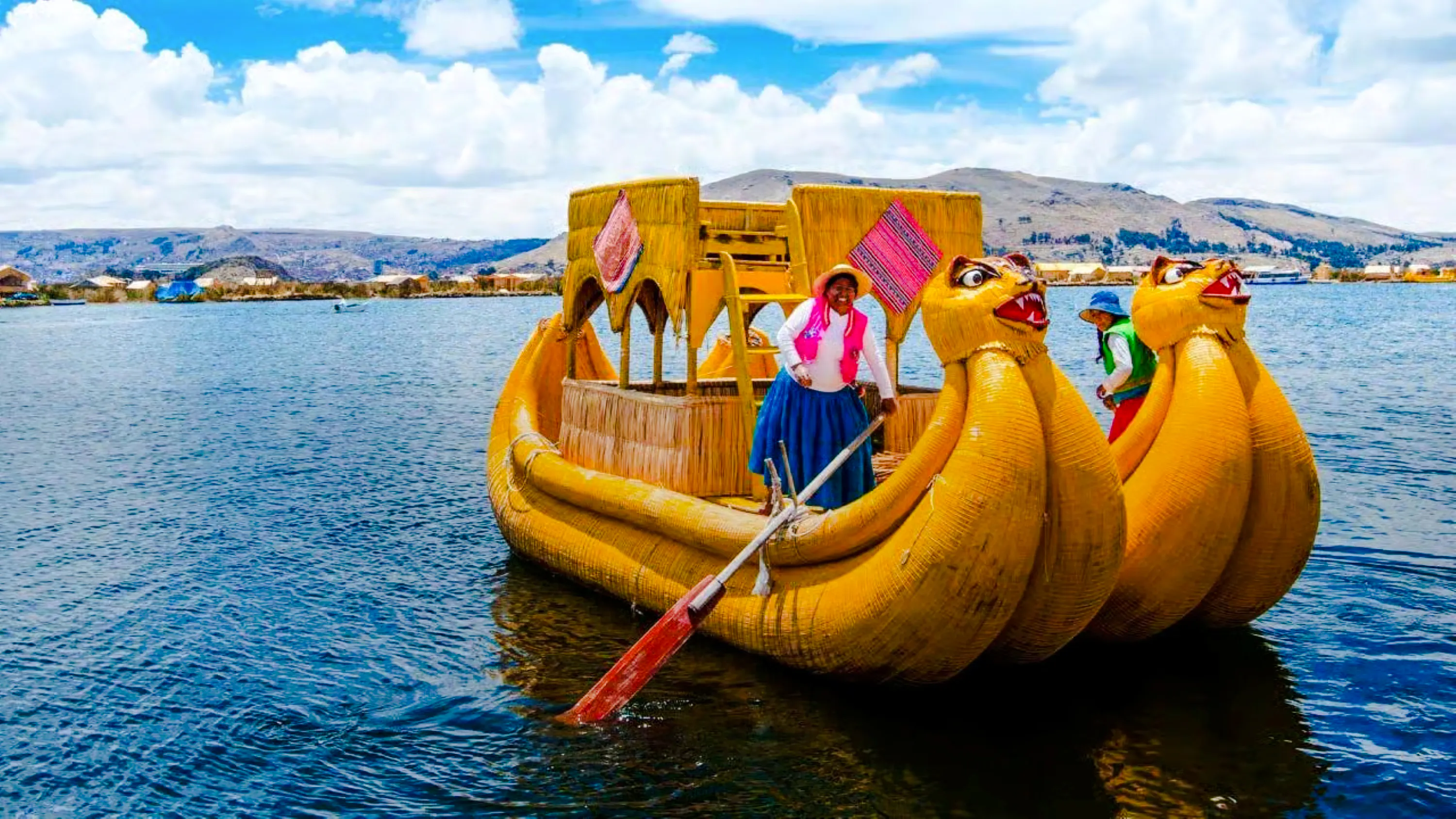 Traditional reed boat on Lake Titicaca with locals, Uros Floating Islands, Puno.