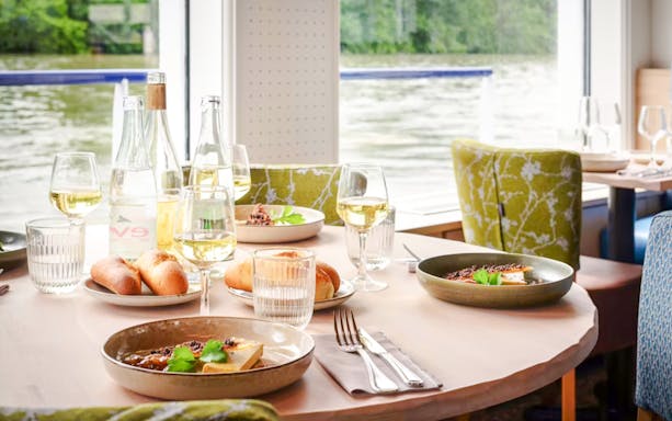 Dining table set with wine and bread on Seine River cruise in Paris.