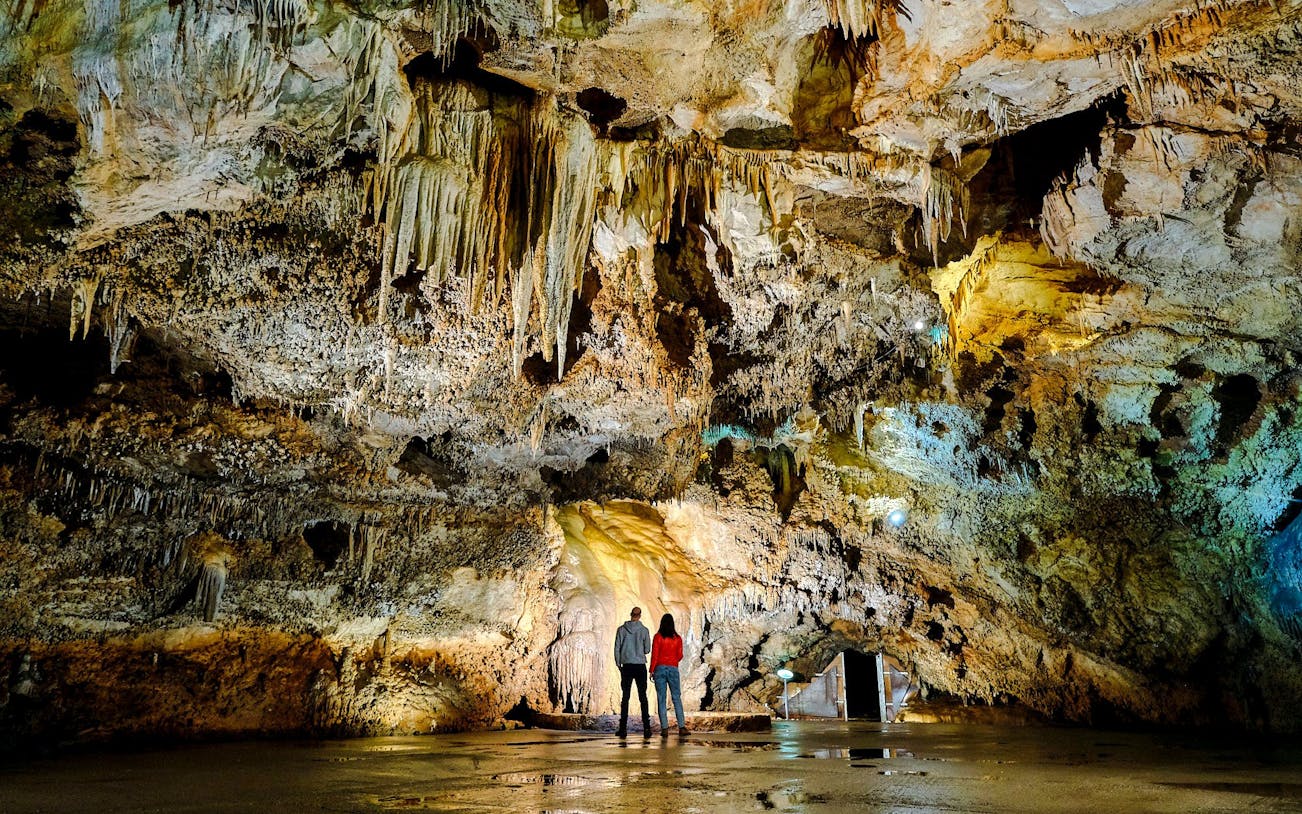Tourists exploring stalactites inside Lipa Cave, Cetinje.