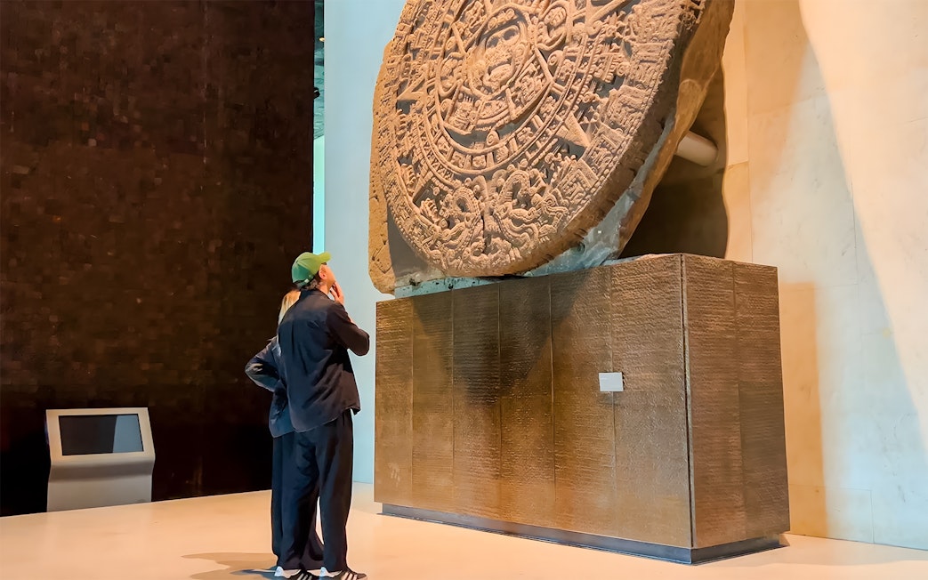 Visitors viewing the Aztec Sun Stone at the National Museum of Anthropology, Mexico City.