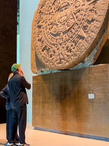 Visitors viewing the Aztec Sun Stone at the National Museum of Anthropology, Mexico City.