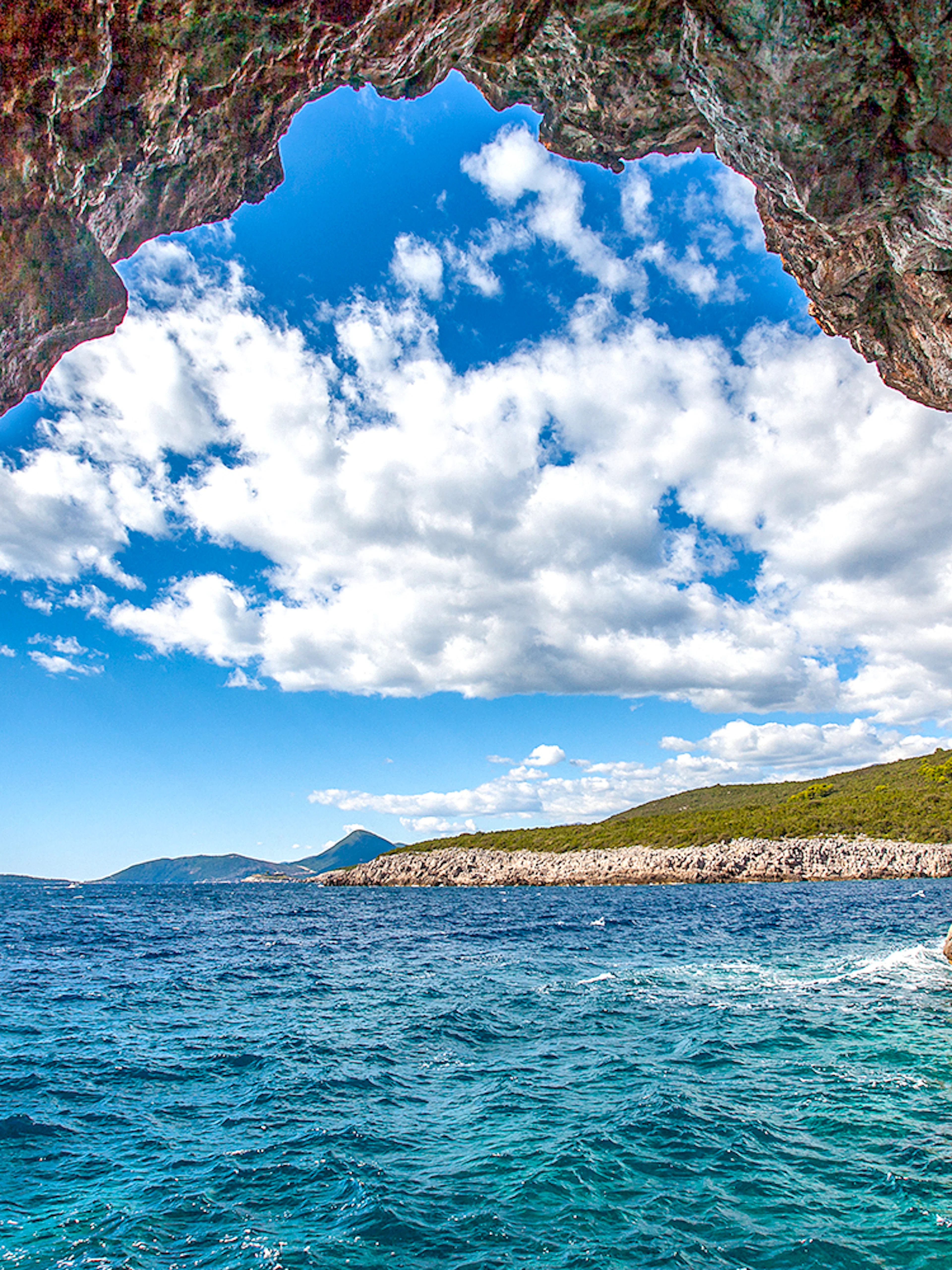 Blue cave entrance with view of Montenegro coast and clear sea.