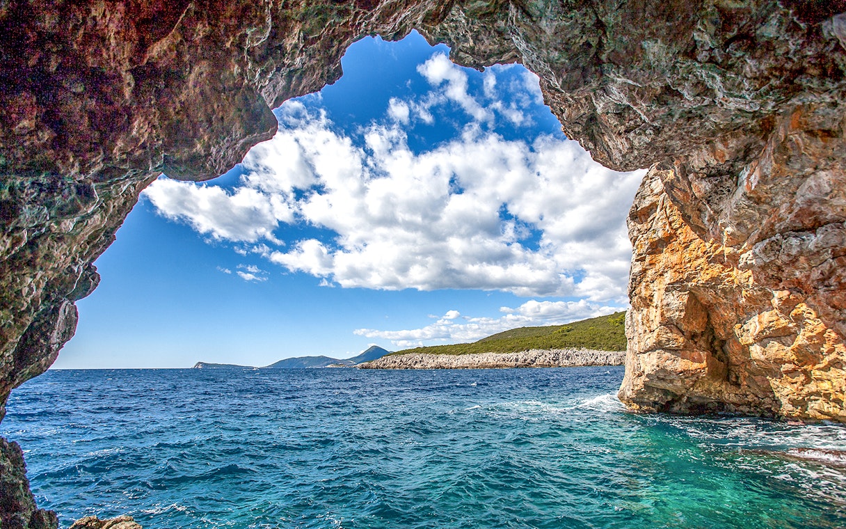 Blue cave entrance with view of Montenegro coast and clear sea.