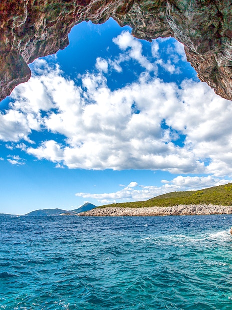 Blue cave entrance with view of Montenegro coast and clear sea.