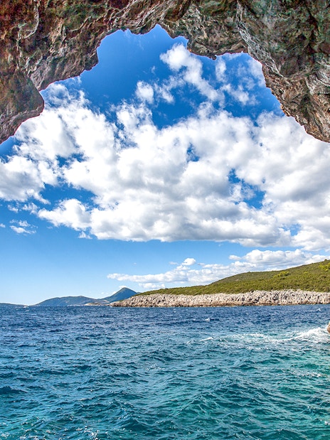 Blue cave entrance with view of Montenegro coast and clear sea.