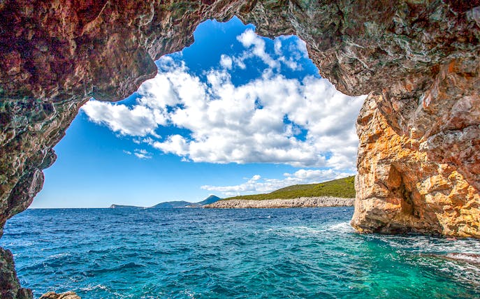 Blue cave entrance with view of Montenegro coast and clear sea.