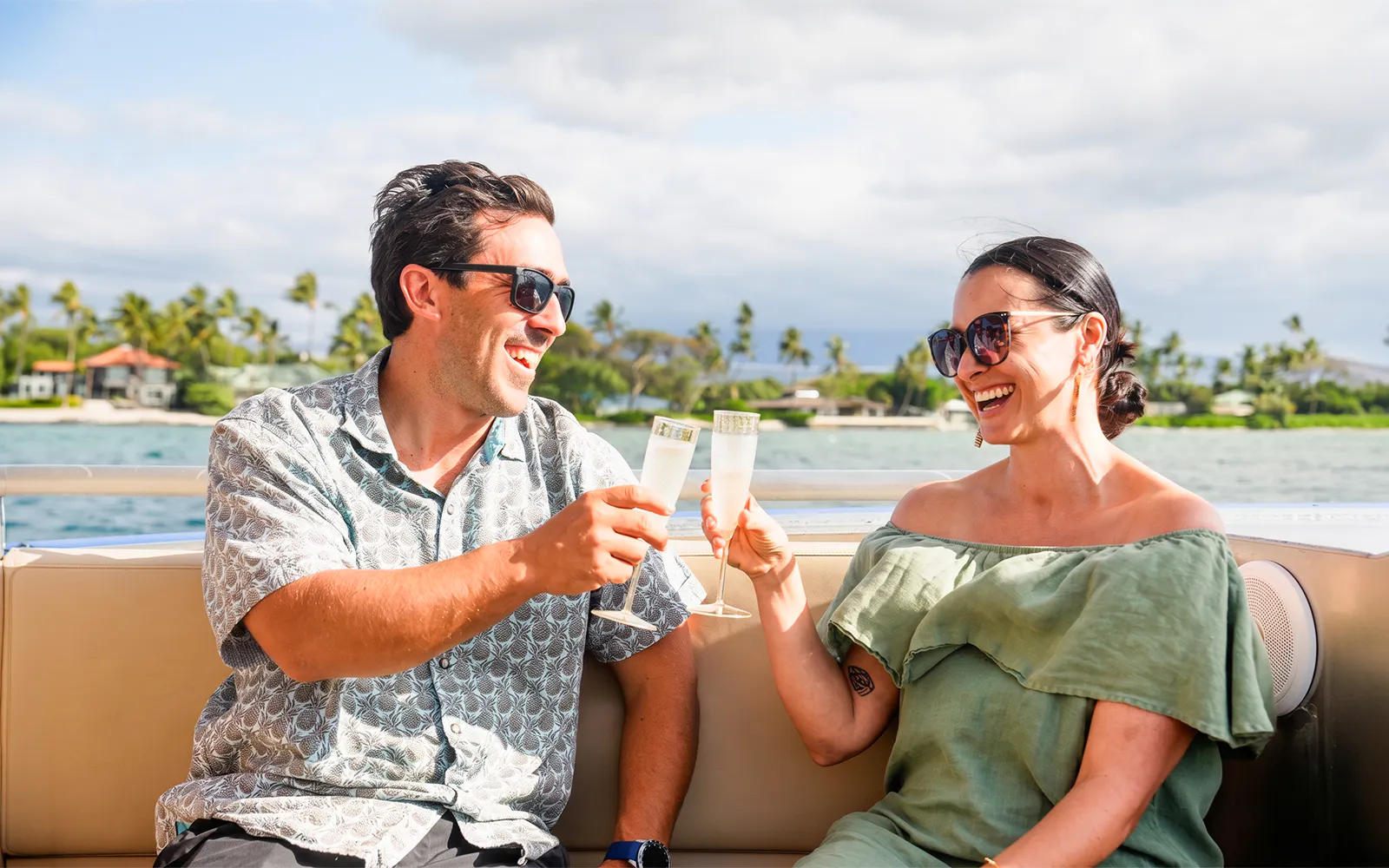 Guests toasting with drinks on a boat along Big Island’s Kohala Coast.