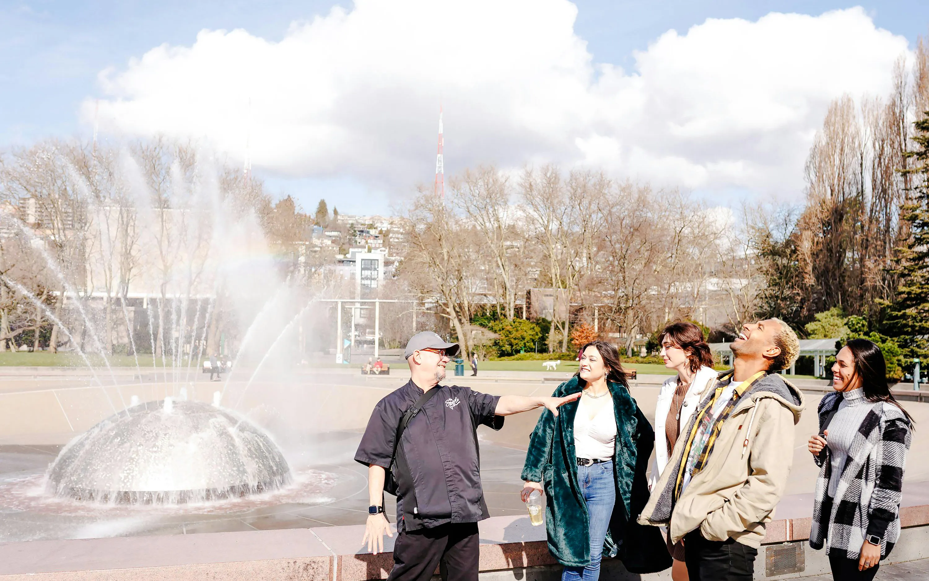 Visitors enjoying the International Fountain at Seattle Center during a food tour.