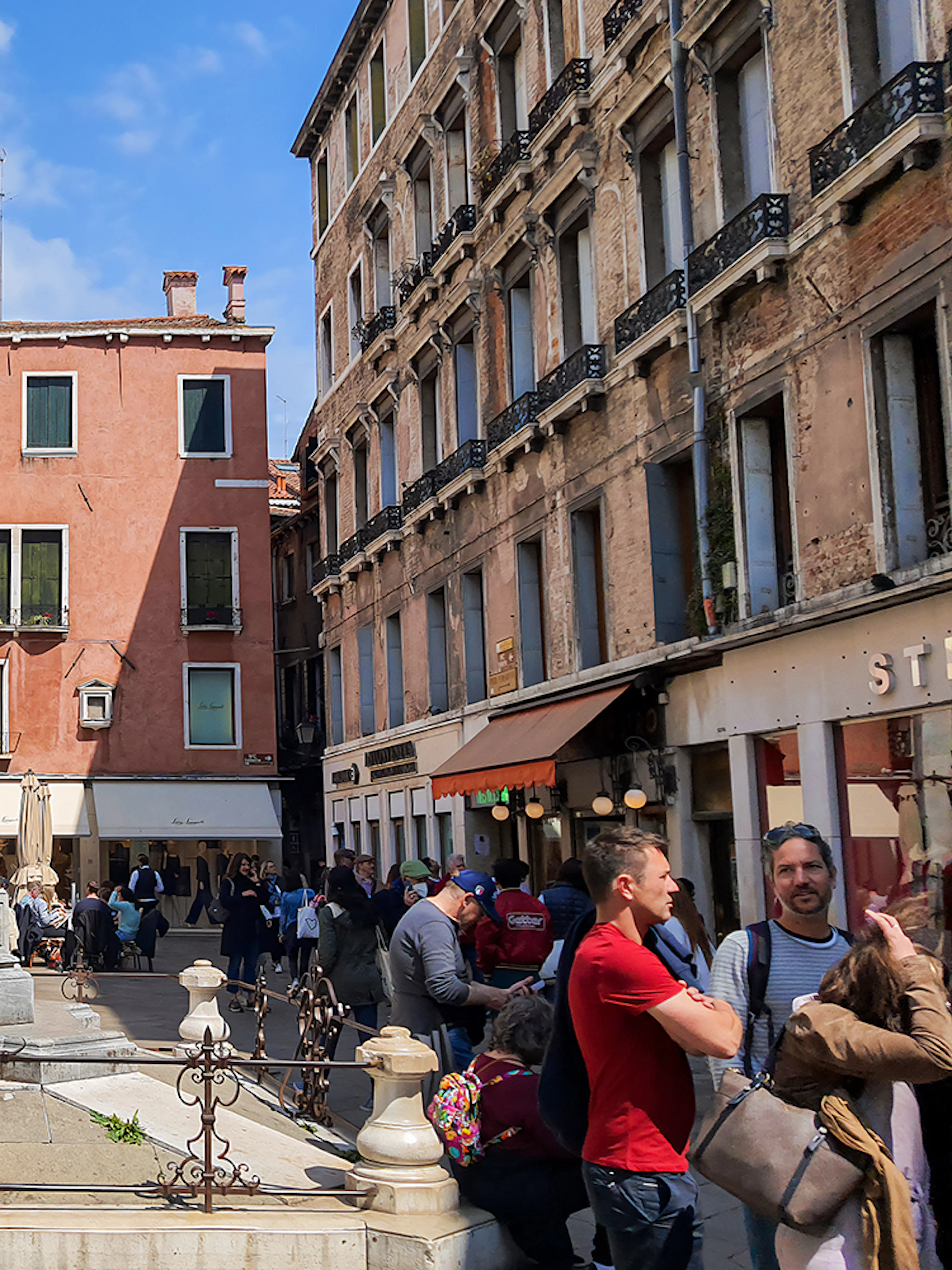 Statue of Carlo Goldoni in a bustling Venetian square, part of a guided culinary and sightseeing tour.