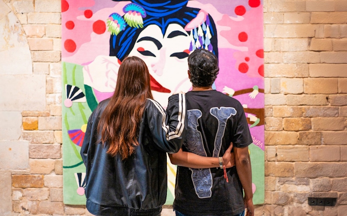 Couple viewing colorful artwork at Moco Museum, Amsterdam.