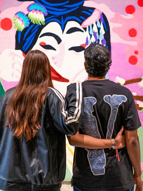 Couple viewing colorful artwork at Moco Museum, Amsterdam.