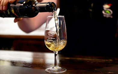 Pouring white wine into a glass at La Geria wine tasting.