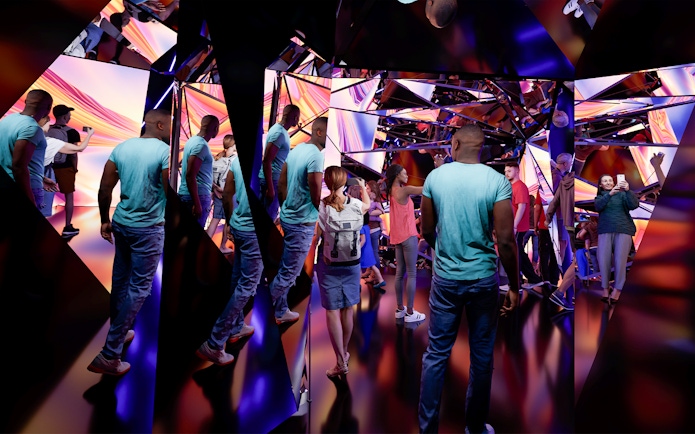 Visitors exploring the mirrored kaleidoscope installation at Edge Experience, NYC.