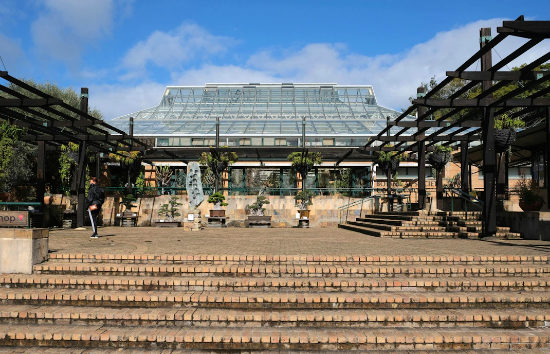 Kirstenbosch Botanical Garden entrance with glass conservatory and stone steps.