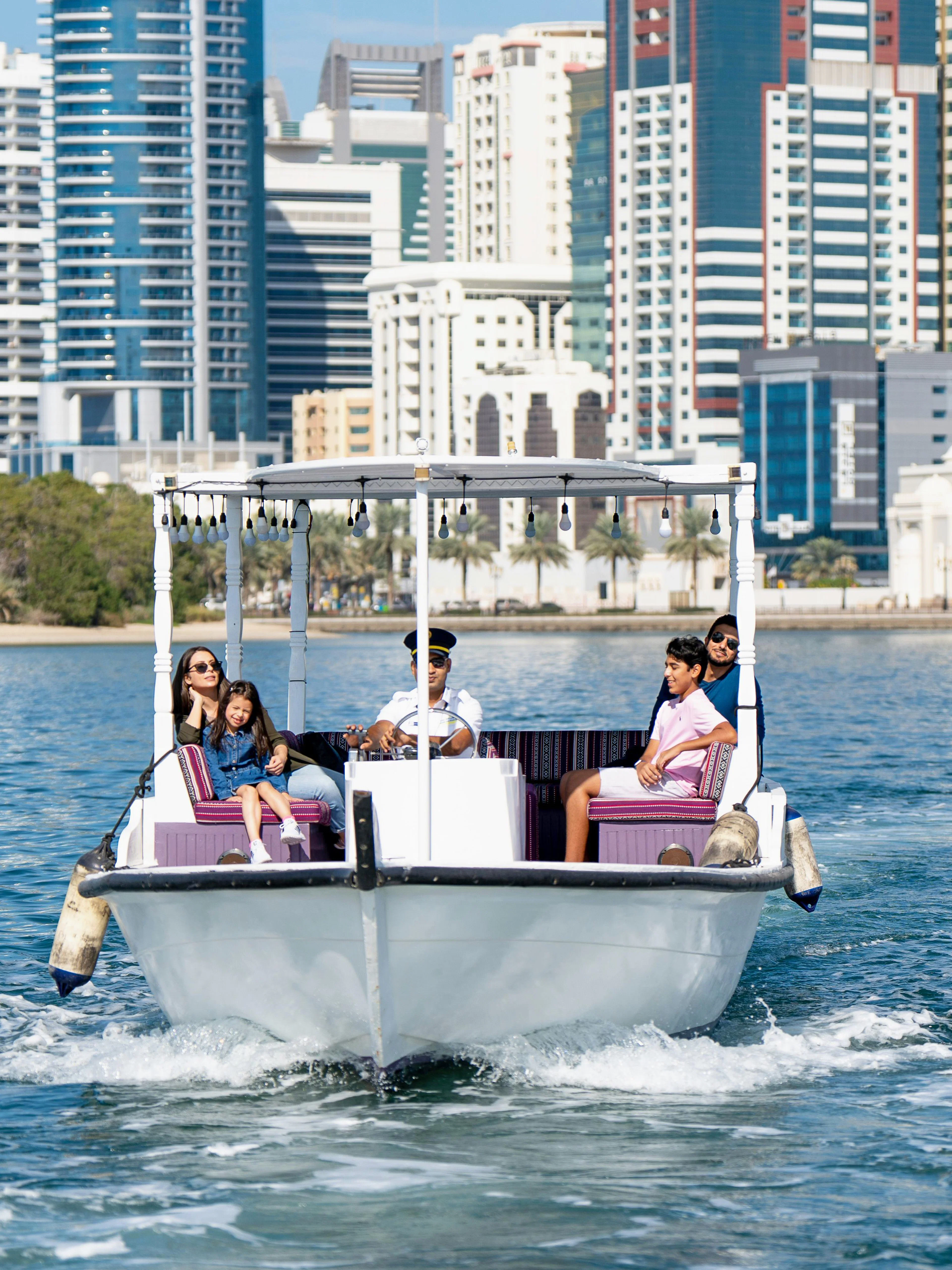 Boat tour on Khalid Lagoon with Sharjah skyline in the background.