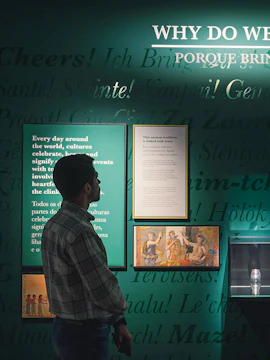 Man observing exhibit on global toasting traditions at The Bridge Collection.