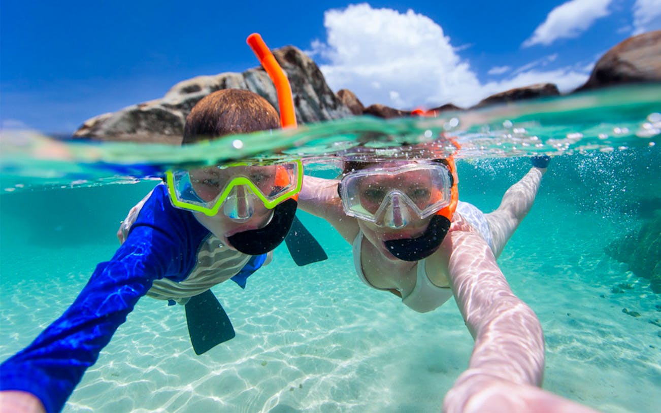 Snorkelers exploring clear waters in coastline coves.