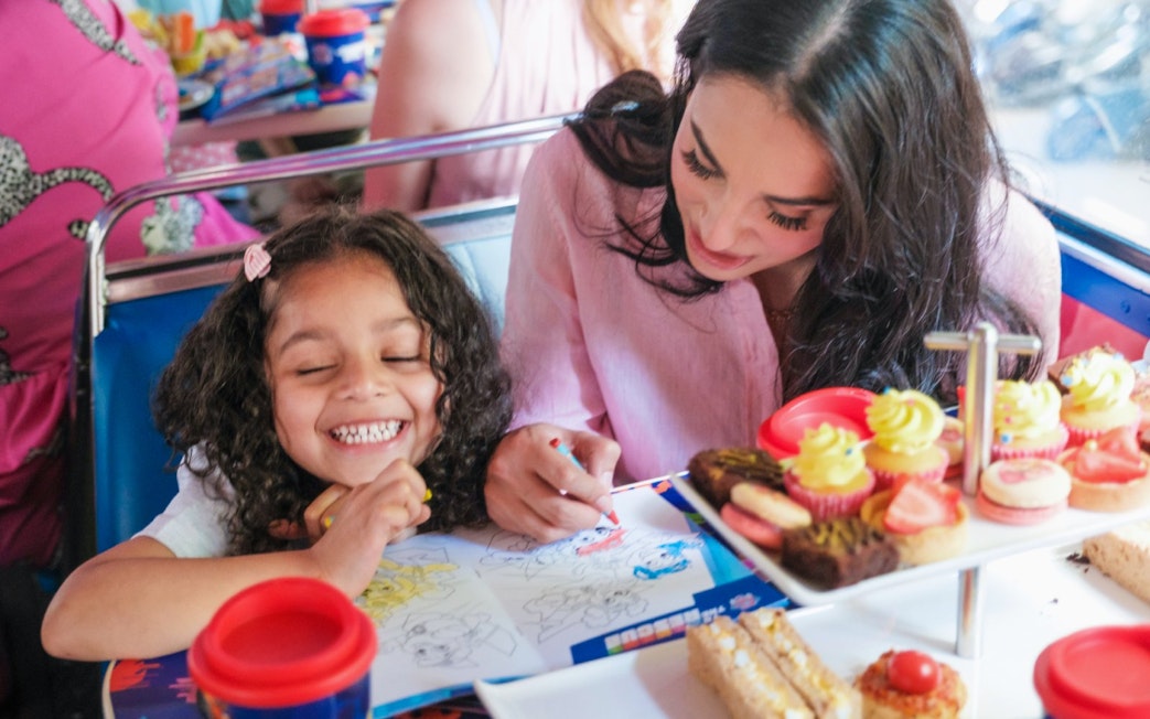 Kids and parents coloring and enjoying treats aboard the Paw Patrol bus.