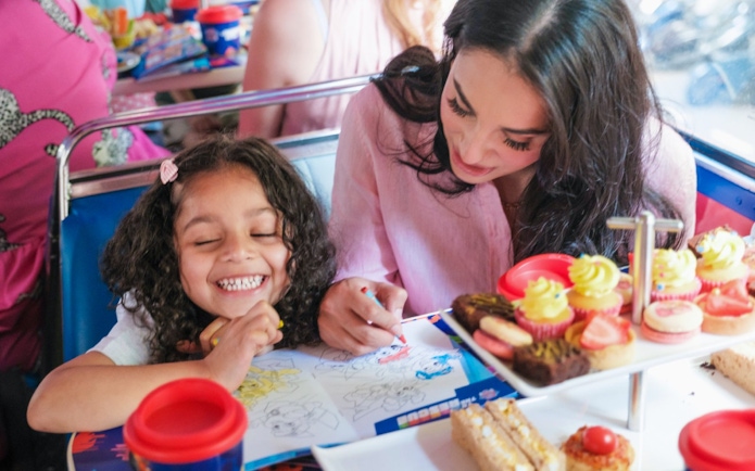 Kids and parents coloring and enjoying treats aboard the Paw Patrol bus.